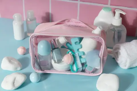 Różowa kosmetyczka z zawartością, w tym szklane perfumy, idealna do bagażu podręcznego Ryanair.