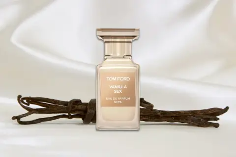 Flakon perfum Tom Ford Vanilla Sex na tle jedwabiu, obok lasek wanilii.